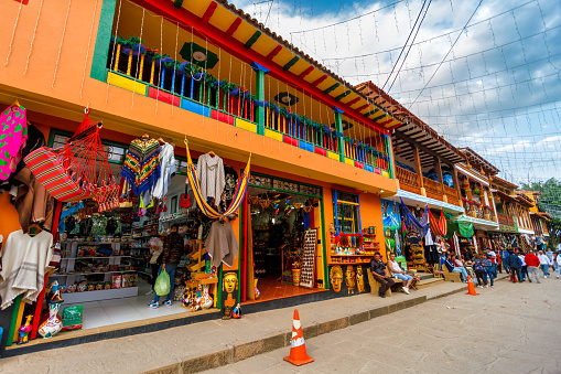 Raquira, Colombia - January 5, 2023: Handicraft and souvenir shops in colorful colonial buildings of the town market