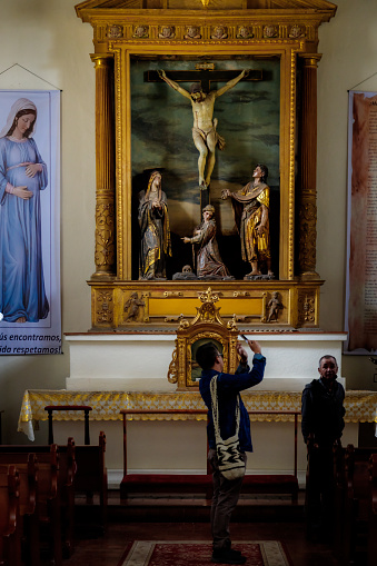 Tunja, Colombia - January 4, 2023: Man takes photos with his mobile phone of different parts of the city's Cathedral