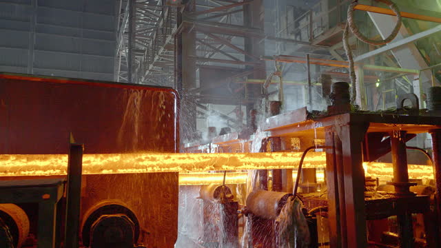 Heated steel tubes cool while moving on the conveyor from the furnace.