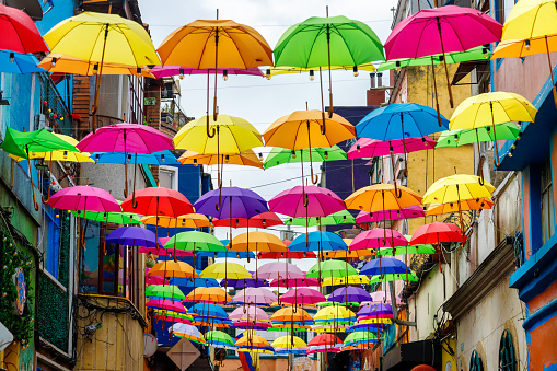 Bogota, Colombia - January 2, 2023: Dozens of hanging colored umbrellas decorate a street in Bogota, Colombia