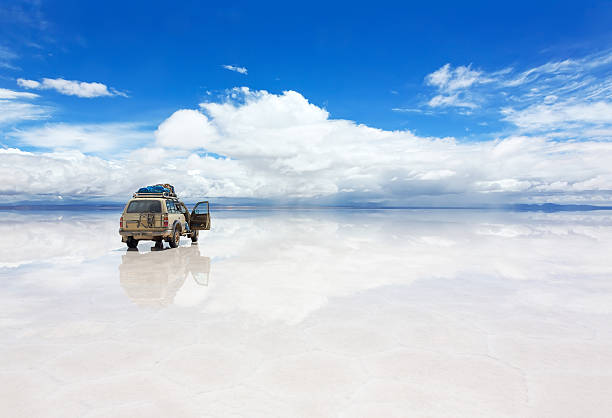 Jeep on the Uyuni Salar in Bolivia Jeep on the reflected surface of Salar de Uyuni lake in Bolivia bolivia stock pictures, royalty-free photos & images