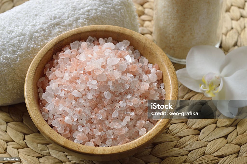 Pink salt from the Himalaya. Pink salt from the Himalaya. Closeup of pink SPA salt in wooden bowl with orchid flower and towel. Alternative Therapy Stock Photo