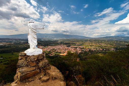 Statue of Jesus on top of a hill with a panoramic view of the Colombian town Villa de Leyva