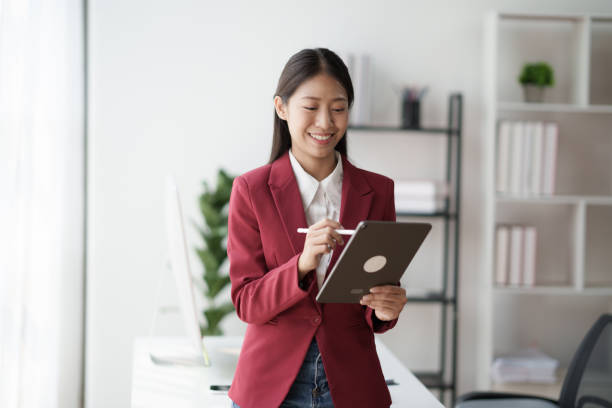 istock Asian businesswoman studying stock chart using digital tablet in office 1625585567
