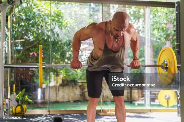 Young Athlete Man Exercising With Barbell In The Gym Stock Photo - Download Image Now