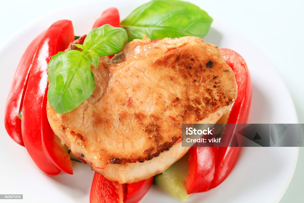 Chuleta de cerdo con pimienta roja y varillas de calabacín - Foto de stock de Albahaca libre de derechos