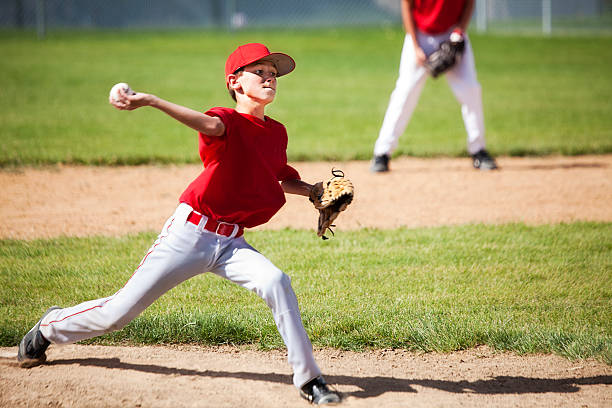 Young Male Baseball Pitcher Powers through Delivery A 12 year old boy pitches from mound. youth baseball and softball league photos stock pictures, royalty-free photos & images