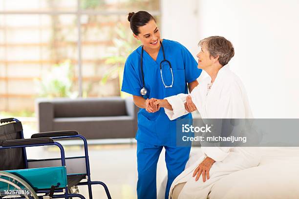 Young Female Caregiver Helping Senior Woman Stock Photo - Download Image Now - Patient, Nurse, Assistance