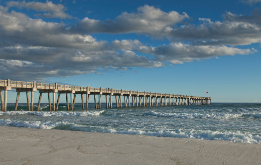 waves crashing the pillars of pier on a beautiful Florida Beach