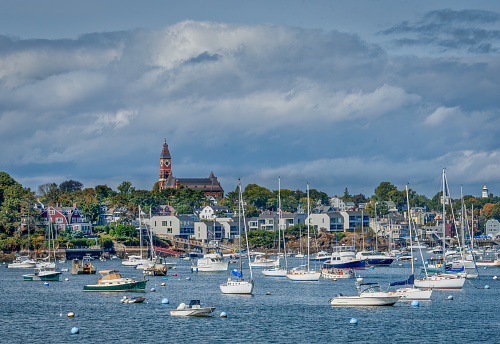 A view of Marblehead Harbor, showing both working boats and pleasure boats, with Abbot Hall, the town hall, looking down from the heights of the business district.