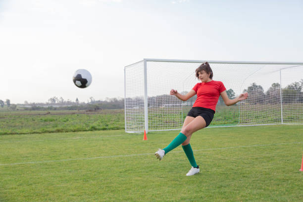 A motivation soccer player with a football in a sport uniform wearing in white
