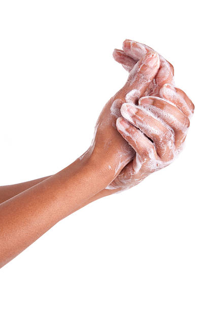 Person washing hands with soap on a white background stock photo