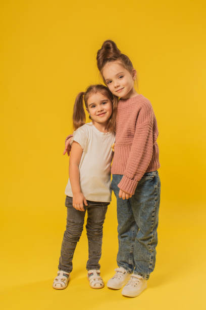 istock Two blonde girls in studio on yellow background 1625853400