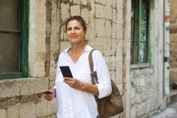 istock Mature woman using smart phone and a credit card 1625860842