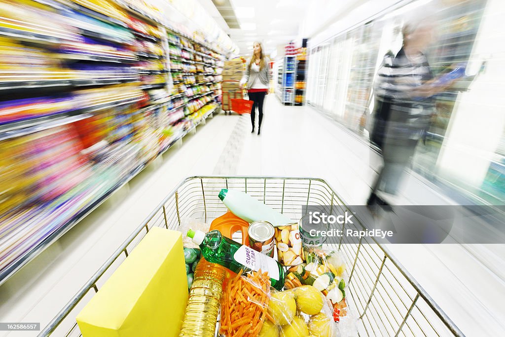 モーションブラー distorts スーパーマーケットの棚の下にあるショッピングカートの速度 - 1人のロイヤリティフリーストックフォト