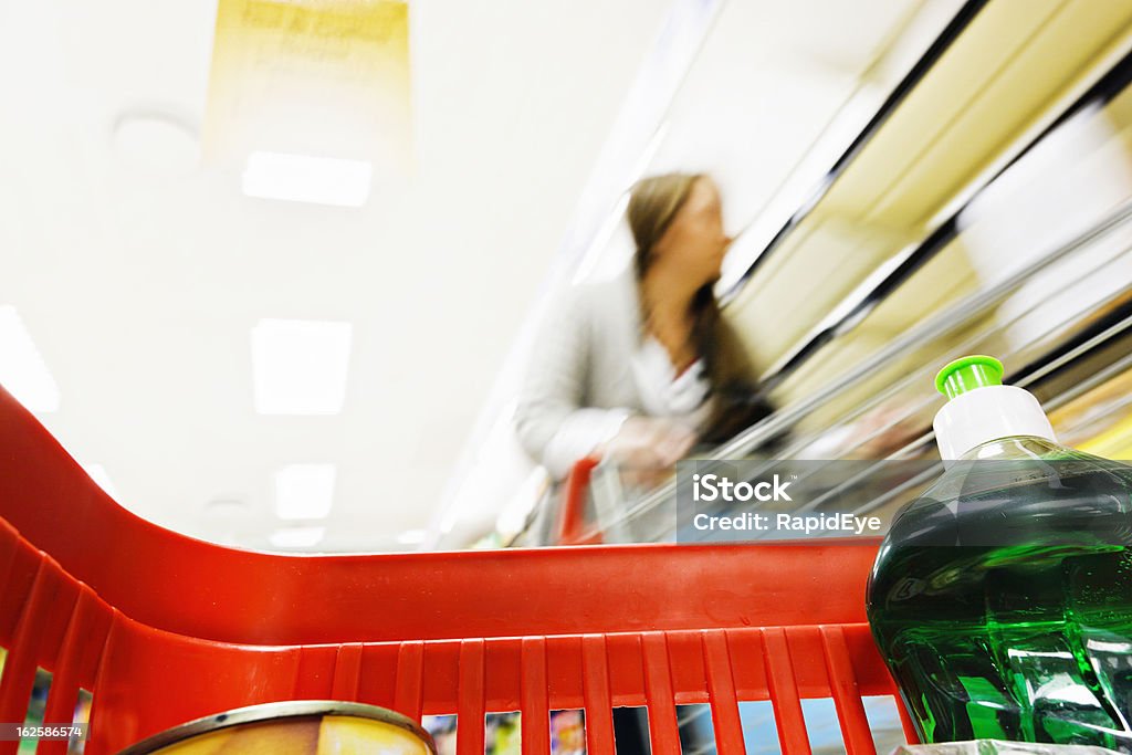 Guardando dall'interno di supermercato shopping bag in out-of-focus donna - Foto stock royalty-free di Immagine mossa