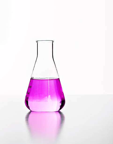 istock Glass laboratory flask with pink fluid, backlit against white 162586621
