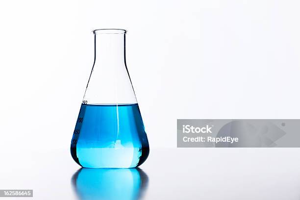 Ein Leuchtendes Glas Lab Glaskolben Hälfte Gefüllt Mit Blau Flüssig Stockfoto und mehr Bilder von Glaskolben