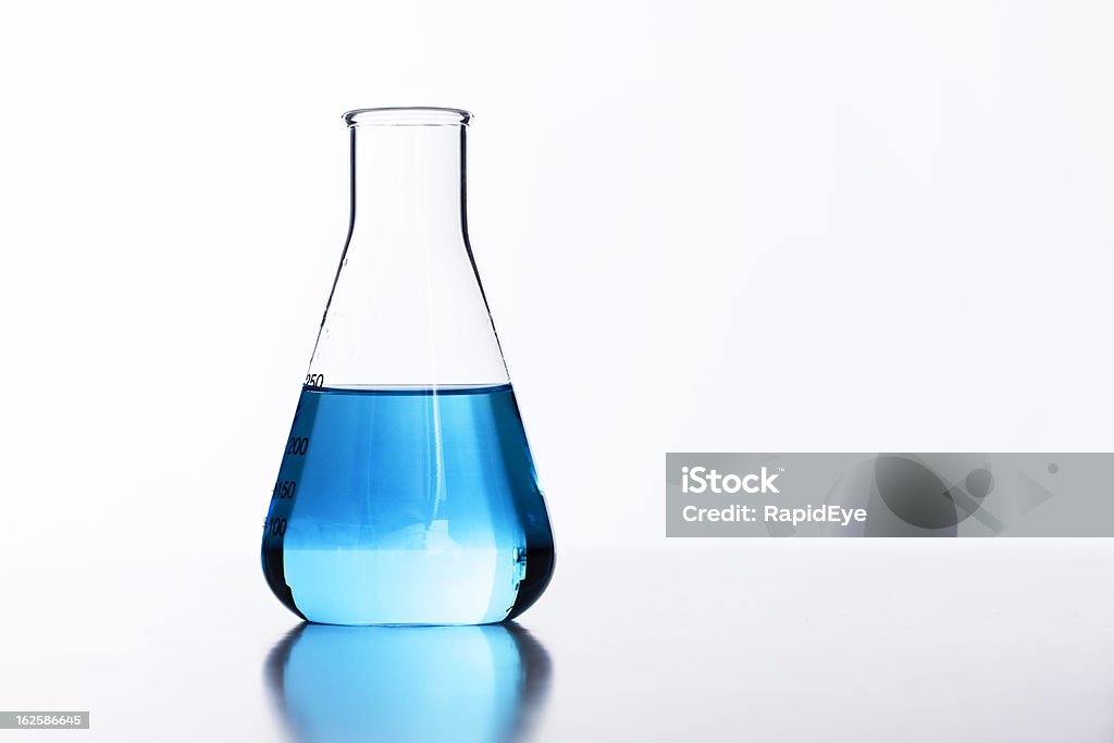 Retroiluminado matraz de vidrio de laboratorio media equipada con líquido azul - Foto de stock de Laboratorio libre de derechos