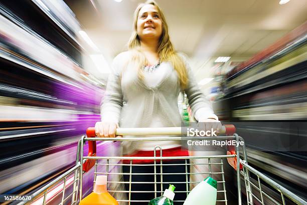 Rubia Carreras De Compras Por El Supermercado Con Desenfoque Multicolored Foto de stock y más banco de imágenes de Carrito de la compra