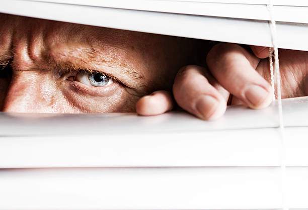 istock Frowning man peeps through venetian blinds 162587117