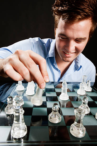 istock Young male chess player smiles as he makes his move 162587226