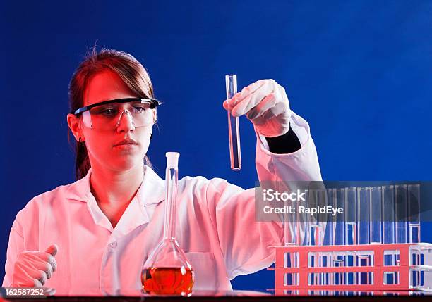 Photo libre de droit de Jeune Femme Scientifique Chèques De Produits Chimiques Dans Le Tube À Essai De Se Concentrer À Fond banque d'images et plus d'images libres de droit de Adulte