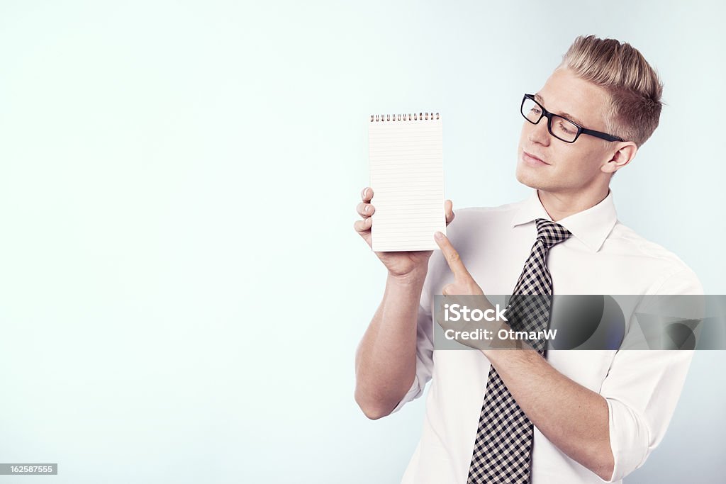 Empresario mirando y señalando con el dedo en vacío Bloc de notas. - Foto de stock de Adulto libre de derechos