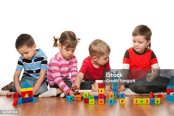 Four Children Are Playing On The Floor Stock Photo - Download Image Now - Alphabet, Boys, Capital Letter
