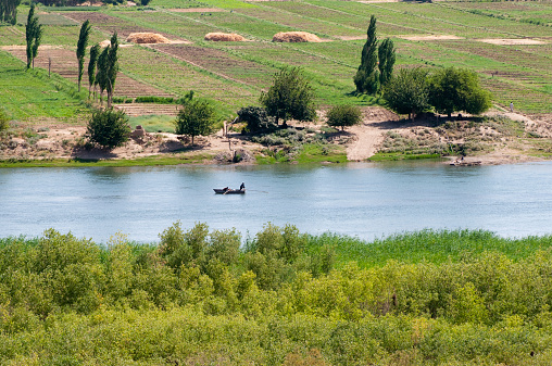 Fishermen work from a boat on the Euphrates river near Dura Europos (Tell Salhiye), Syria, just a few miles north of where the river flows into Iraq. The region is barren desert, except for the irrigated fields along the banks of the river.