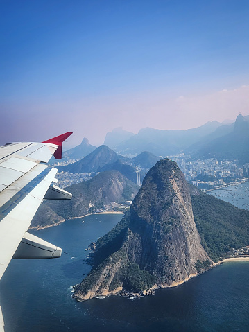 Airplane window view of the Sugarloaf Mountain and other landmarks of Rio de Janeiro, Brazil.
