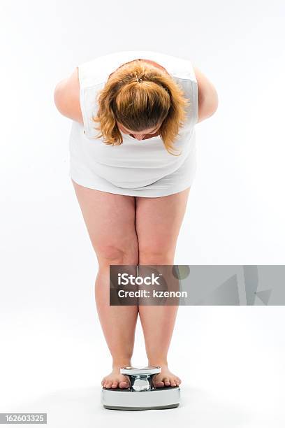 Obese Young Woman Standing On A Scale Stock Photo - Download Image Now - Weight Scale, Women, Overweight