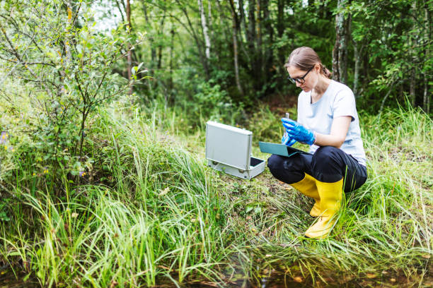 Mature woman collected river water sample for analysis