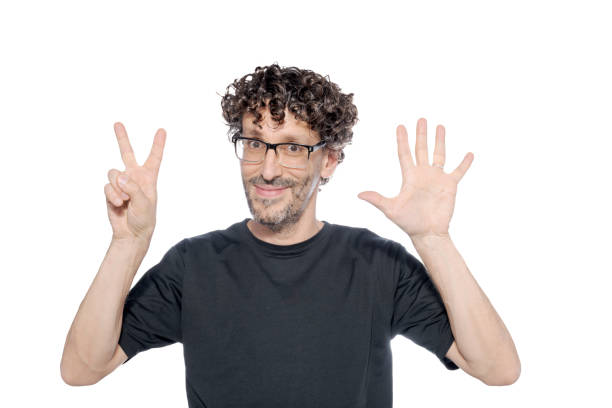 Middle-aged man making the number seven with his fingers, on white background.