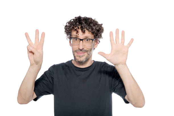 istock Middle-aged man making the number eight with his fingers, on white background. 1626069876