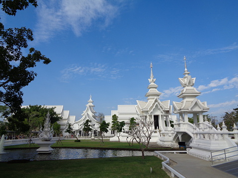 White temple and blue sky and tree green grass is the nice weather