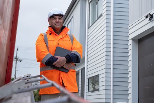 A portrait of a male building inspector in safety workwear