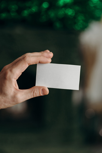 A man holding an empty business card. Empty mock up card.