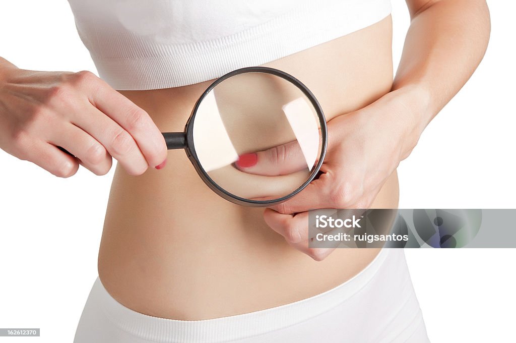 Pinching Fat Woman pinching fat from her waist and examining it with a loupe Abdomen Stock Photo