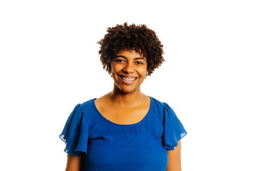 Portrait of black woman wearing braces smiling looking at camera over white background.