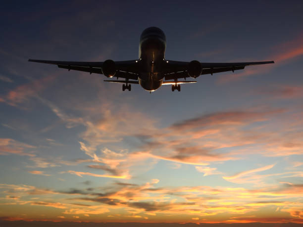 istock White airplane. The plane is flying in the dusk 1626140691