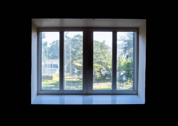 A dirty window looking outside from a dark room