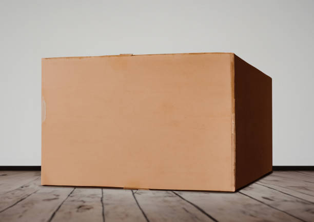 istock A box standing on the floor. Wooden floor and a white wall 1626173982