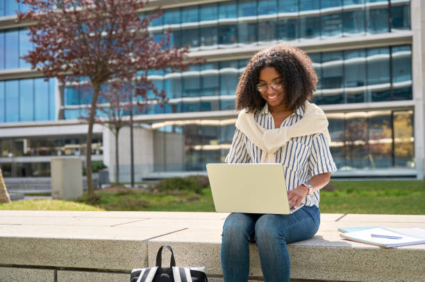 istock Young happy African American girl student using laptop learning in park. 1626181719