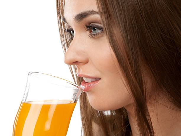 Young woman drinking juice, on the white background stock photo