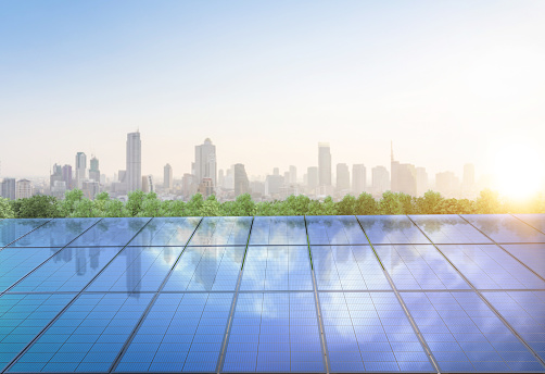 3d rendering amount of solar panels on green field or solar farm againt blue sky and cityscape background