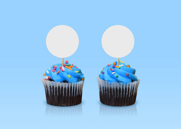Blue Cupcake Topper Mockup - Blue Cupcakes on Blue Background Two blue frosted cupcakes standing boldly against a cool blue background. cake models stock pictures, royalty-free photos & images