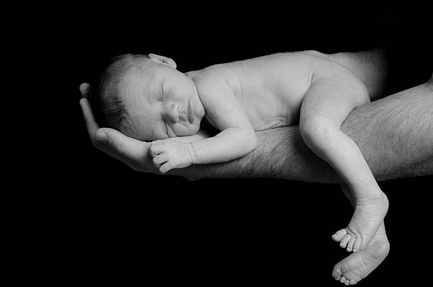 istock Newborn Lies in Daddy's Arms with Legs Dangling 162623650