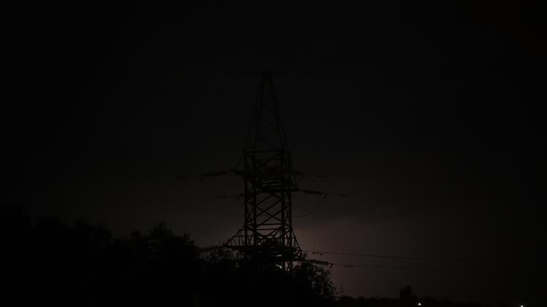 High voltage power line during heavy thunderstorm and bright lightning.