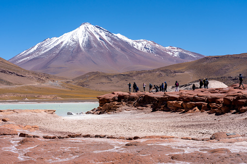 San Pedro de Atacama, Chile - February 23, 2023: Tourists visiting Red Rocks (Piedras Rojas), lagoon and salt flats  in Atacama Desert, Chile.
